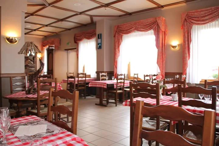 Salle historique Au Sapin avec tables à carreaux rouges